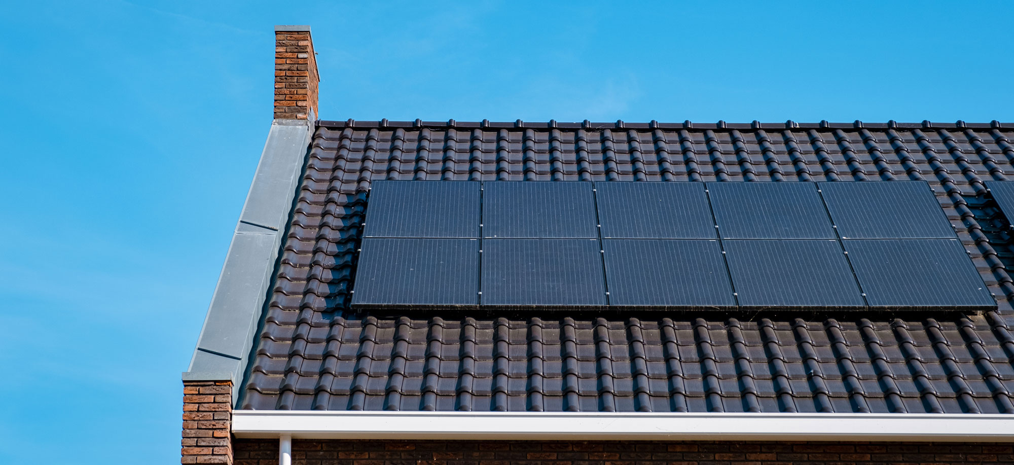 A house with solar panels on the roof illustrating the use of renewable energy.